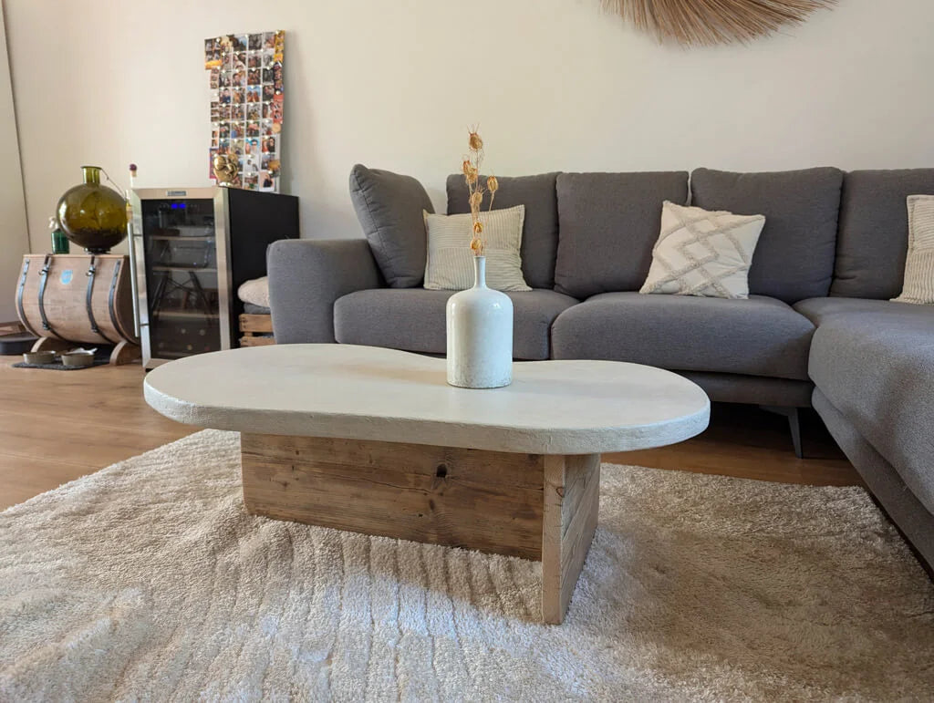 Table basse Florence en bois recyclé et plateau en argile, mise en scène dans un salon moderne avec canapé gris et décor chaleureux.