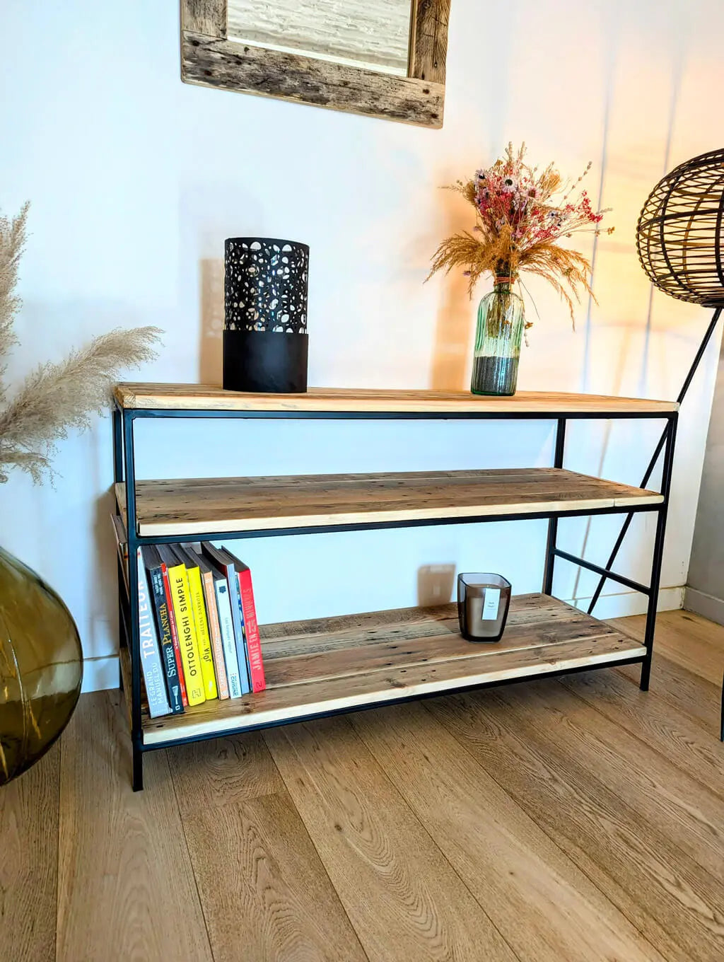 Étagère Louise en bois recyclé et métal noir, mise en scène avec des livres, une bougie et un vase décoratif dans un intérieur chaleureux.