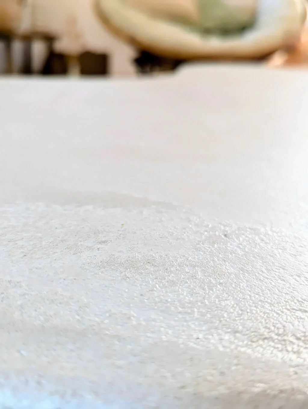 Gros plan sur le plateau en argile naturelle et quartz de la table basse Florence, mettant en avant sa texture minérale et son fini artisanal.
