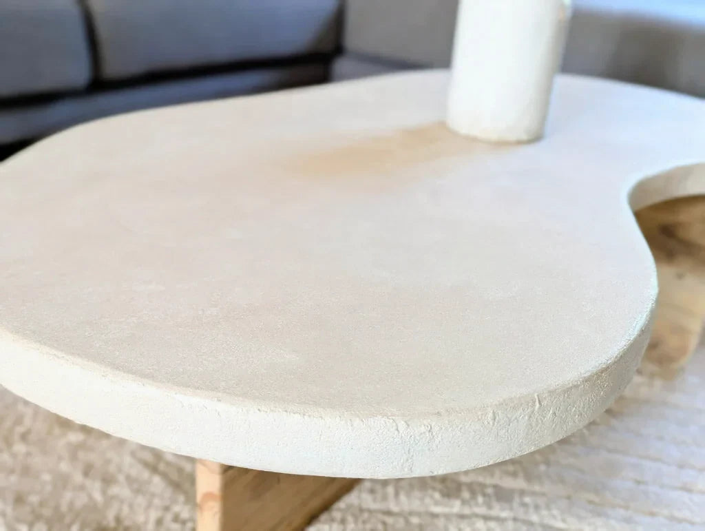 Détail du plateau organique en argile naturelle et quartz de la table basse Florence, avec sa finition texturée et ses bords arrondis élégants.
